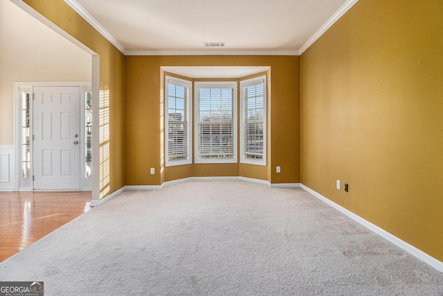 foyer entrance with light colored carpet and crown molding