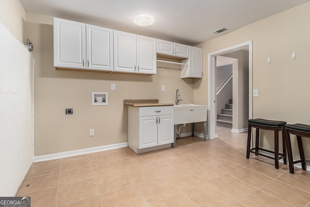 kitchen featuring white cabinets, light tile patterned floors, and sink