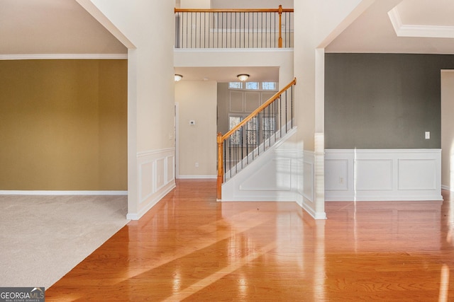 carpeted entryway featuring crown molding