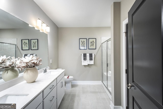 bathroom featuring toilet, a shower with door, and vanity