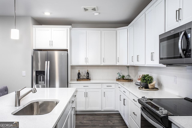 kitchen featuring stainless steel appliances, white cabinets, sink, and backsplash