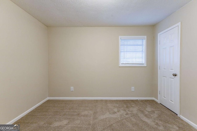 unfurnished room with a textured ceiling and light colored carpet