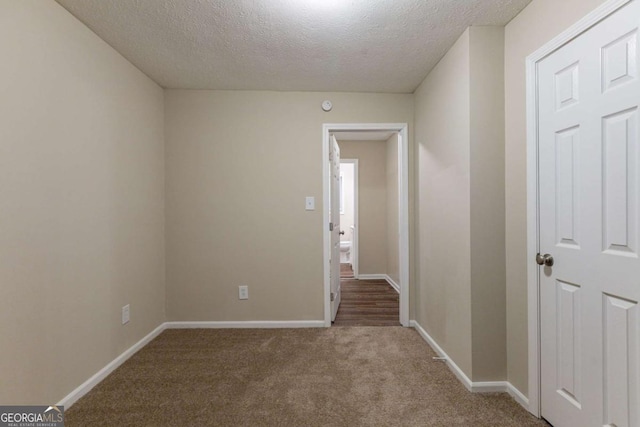 carpeted empty room with a textured ceiling