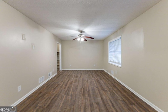 spare room with a textured ceiling, ceiling fan, and dark hardwood / wood-style floors