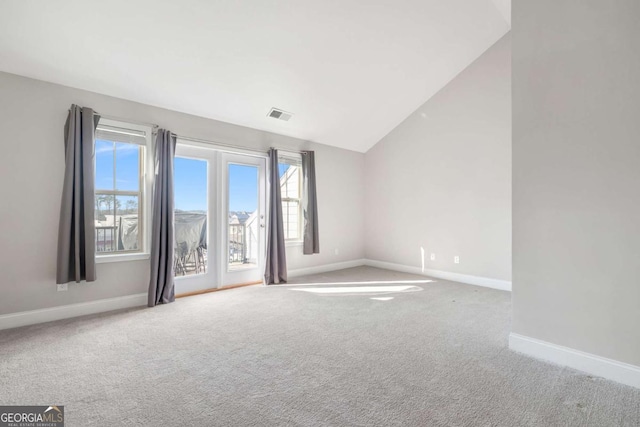 carpeted spare room featuring lofted ceiling