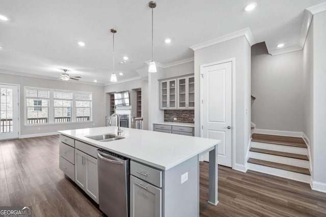 kitchen with ceiling fan, sink, dishwasher, decorative light fixtures, and a kitchen island with sink