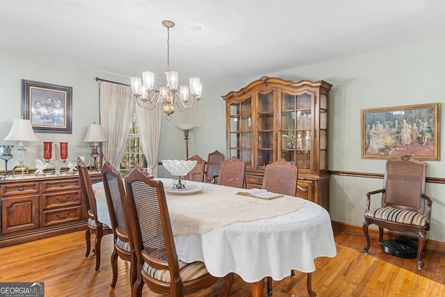 dining room featuring light wood-type flooring and an inviting chandelier