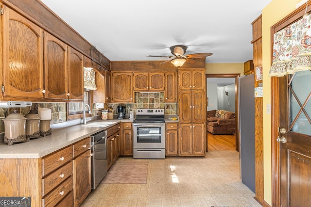 kitchen featuring decorative backsplash, stainless steel appliances, ceiling fan, and sink