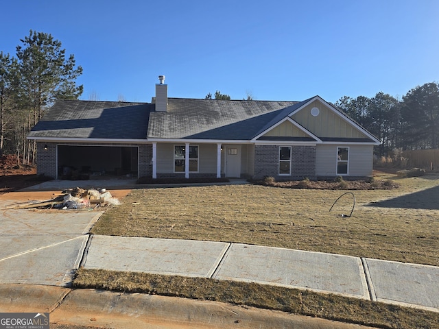 view of front of house with driveway, brick siding, a chimney, and an attached garage