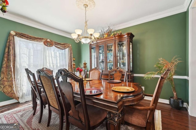 dining area with a chandelier, dark hardwood / wood-style floors, and ornamental molding