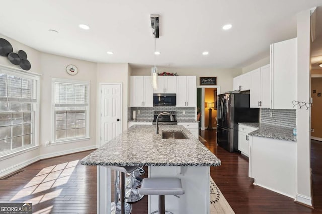 kitchen with light stone countertops, appliances with stainless steel finishes, backsplash, and sink