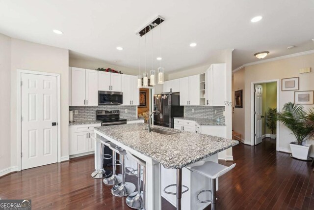 kitchen with white cabinetry, stainless steel appliances, and a breakfast bar area