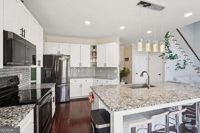 kitchen featuring white cabinetry, sink, backsplash, pendant lighting, and black appliances