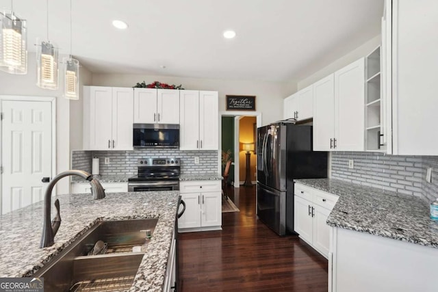 kitchen featuring pendant lighting, backsplash, sink, white cabinetry, and stainless steel appliances