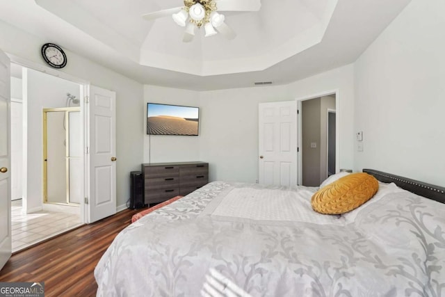 bedroom featuring a tray ceiling, ceiling fan, and dark hardwood / wood-style floors