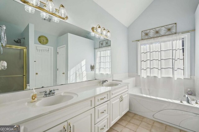 bathroom with tile patterned flooring, vanity, vaulted ceiling, and separate shower and tub