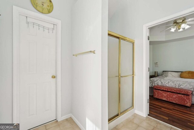 bathroom featuring ceiling fan and a shower with shower door