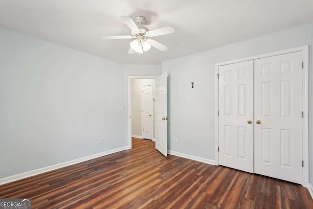 unfurnished bedroom with ceiling fan, dark wood-type flooring, and a closet