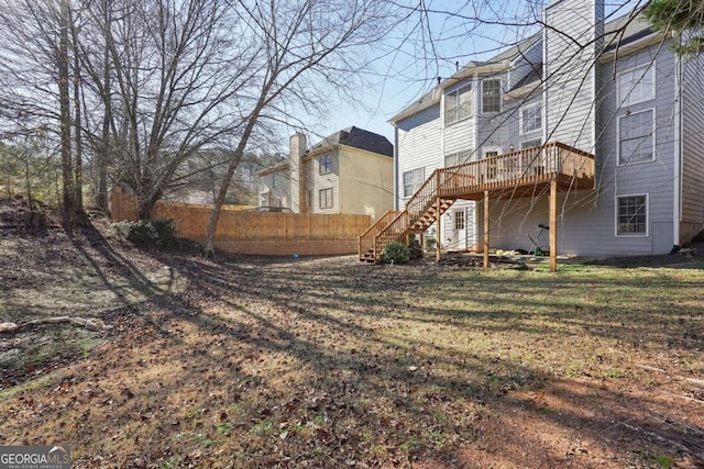 rear view of property featuring a deck and a lawn