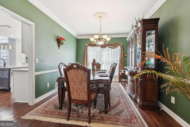 dining area featuring a notable chandelier, dark hardwood / wood-style floors, ornamental molding, and sink