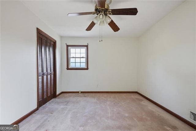 empty room with ceiling fan and light carpet