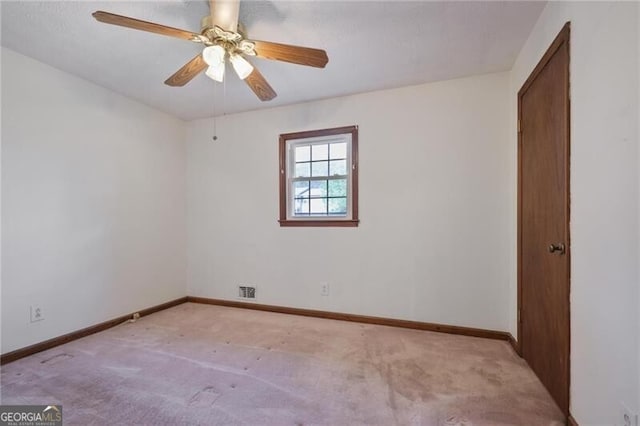 carpeted spare room featuring ceiling fan