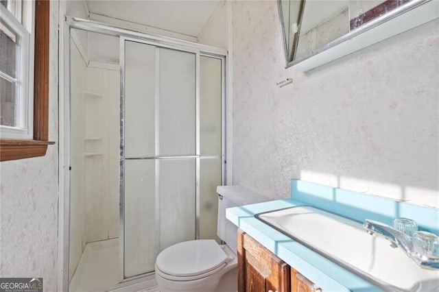 bathroom featuring vanity, an enclosed shower, and toilet