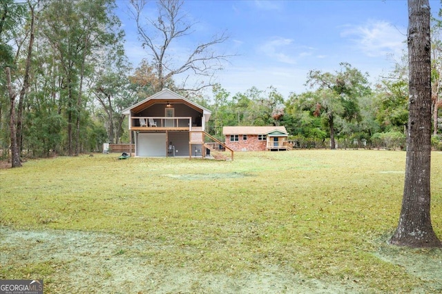 view of yard featuring an attached garage and a wooden deck