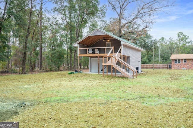 view of front of house with a front yard, fence, a wooden deck, and stairs