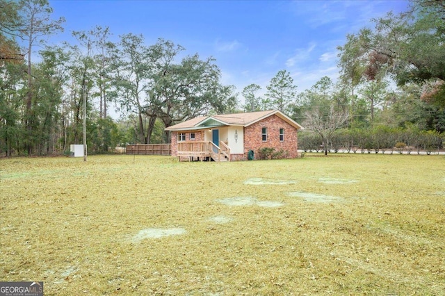 view of front facade with brick siding and a front lawn