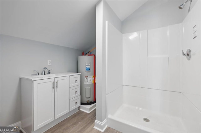 bathroom with a shower, wood finished floors, electric water heater, vaulted ceiling, and vanity