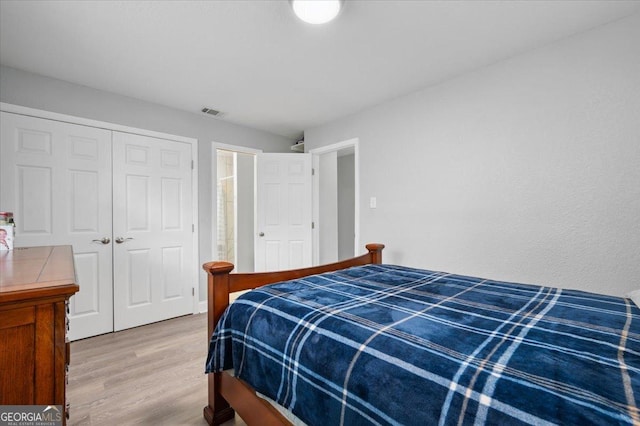 bedroom featuring a closet, visible vents, and wood finished floors