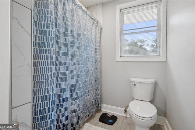 full bathroom featuring toilet, baseboards, and a shower with shower curtain