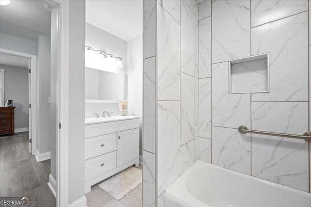 full bathroom featuring baseboards, shower / bathing tub combination, wood finished floors, and vanity