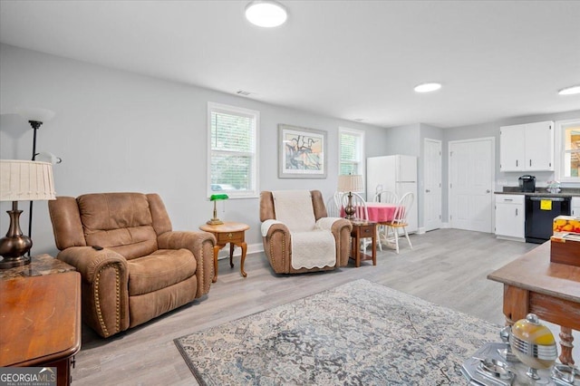 living area with light wood-style floors and visible vents