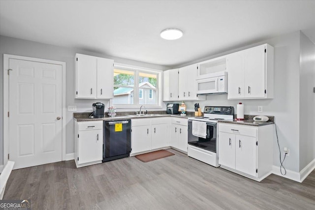 kitchen with white appliances, dark countertops, light wood-style floors, white cabinetry, and a sink