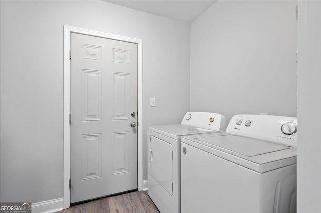 laundry area with baseboards, laundry area, light wood-style floors, and washer and dryer