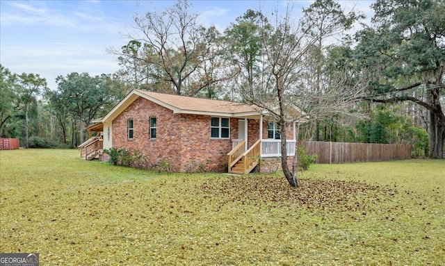 ranch-style home with a front yard, fence, and brick siding