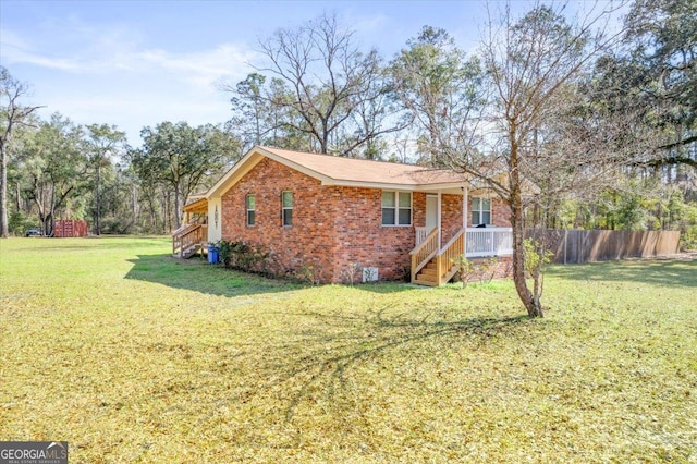 view of front of property with crawl space, a front yard, fence, and brick siding