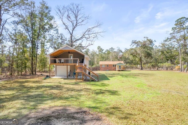 view of yard featuring driveway, stairway, an attached garage, and a wooden deck