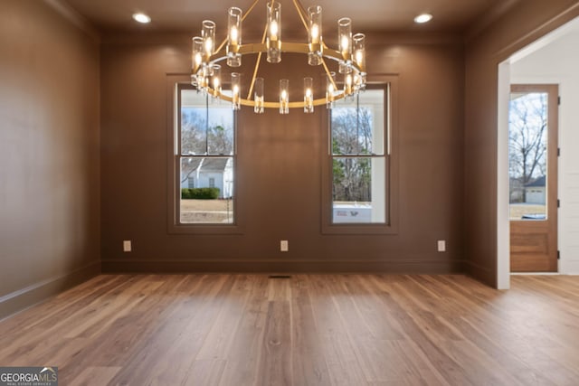 unfurnished dining area featuring recessed lighting, baseboards, and wood finished floors