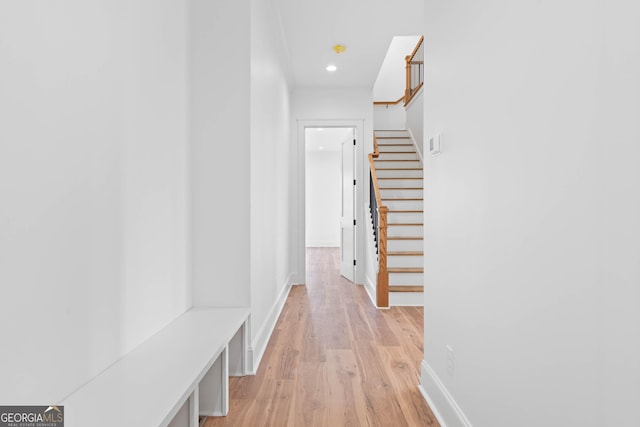 hall with light wood-style flooring, recessed lighting, stairway, and baseboards
