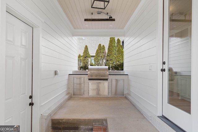 view of patio with exterior kitchen and a grill