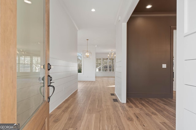 foyer featuring a chandelier, baseboards, wood finished floors, and recessed lighting