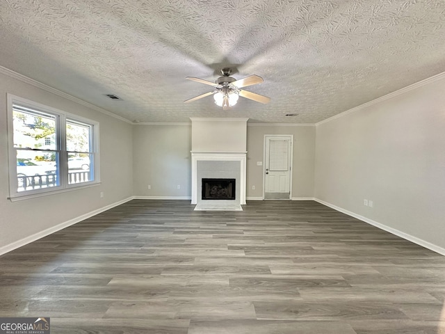 unfurnished living room with hardwood / wood-style flooring, ornamental molding, and ceiling fan