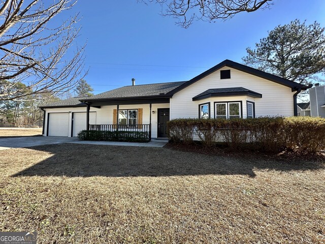 ranch-style home featuring a garage and a front lawn