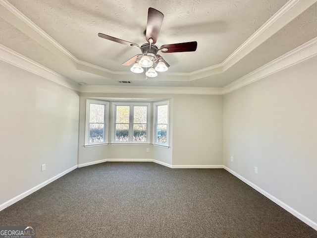 empty room featuring crown molding, carpet floors, a raised ceiling, and ceiling fan