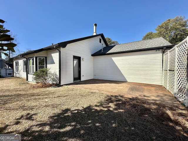 rear view of property featuring a yard and a patio area