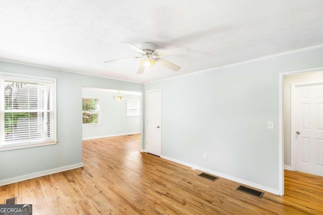 unfurnished room featuring ceiling fan, ornamental molding, and light wood-type flooring