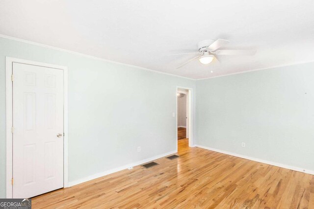 unfurnished room with hardwood / wood-style flooring, ceiling fan, and ornamental molding